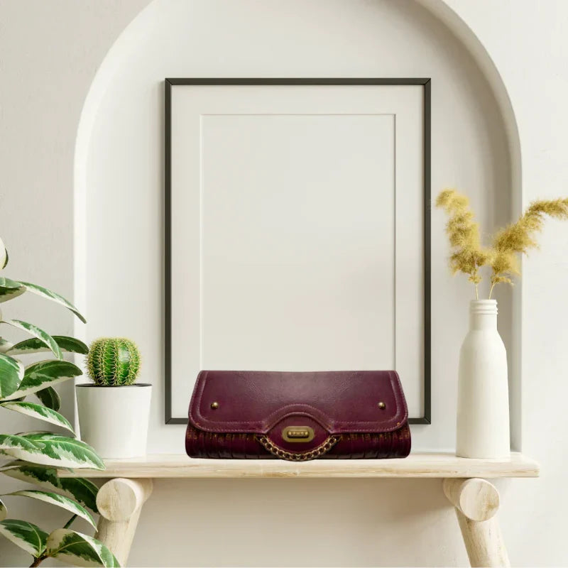 Women’s purple faux leather clutch purse featuring shimmering gold hardware
