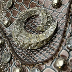 Elegant mini faux leather handbag featuring jeweled detailing and structured design