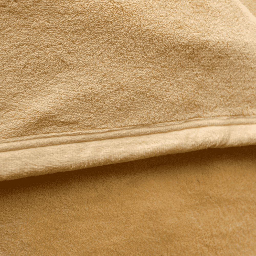 Close-up of velour fleece blanket texture in champagne color, showing plush softness and high-quality finish.